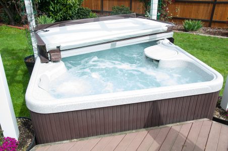 An open hot tub cover is sitting on top of a hot tub.